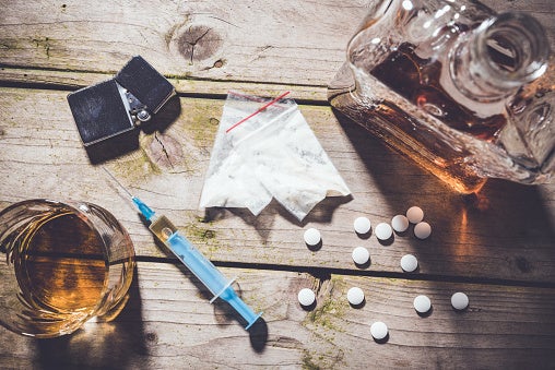 Image of drugs and alcohol displayed on a wooden table